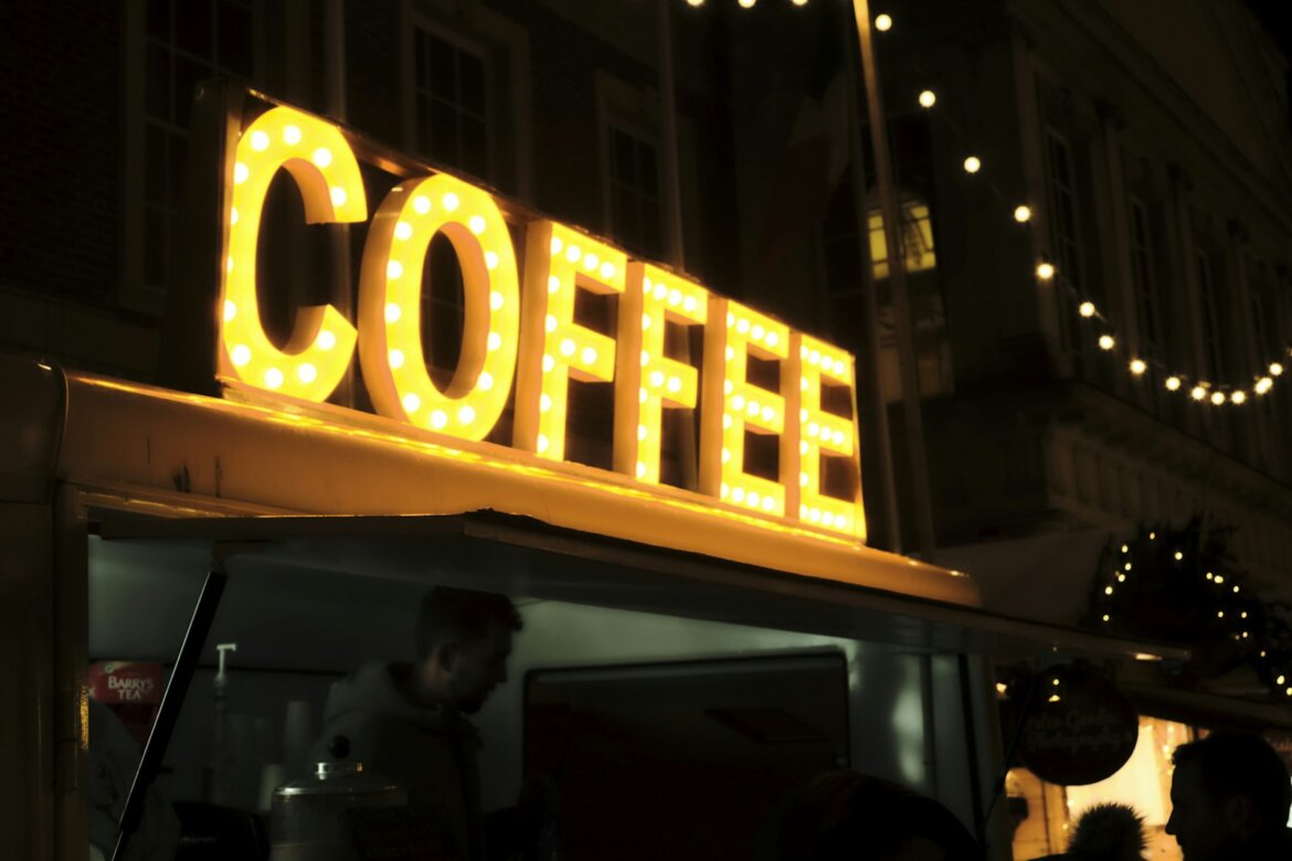 a coffee shop sign lit up at night