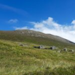 a grassy hill with rocks on it