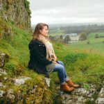 woman sitting on rock
