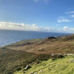 a grassy hill overlooking a body of water