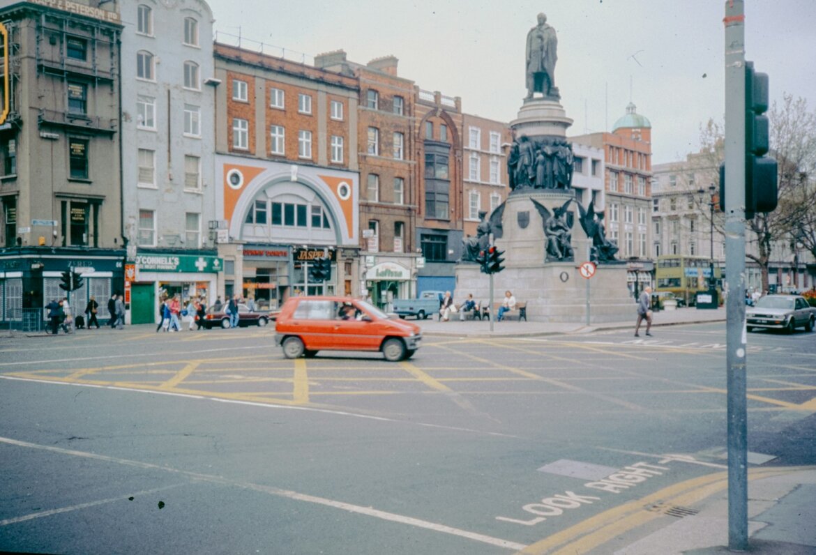 Dublin's o'connell street with a monument and traffic.