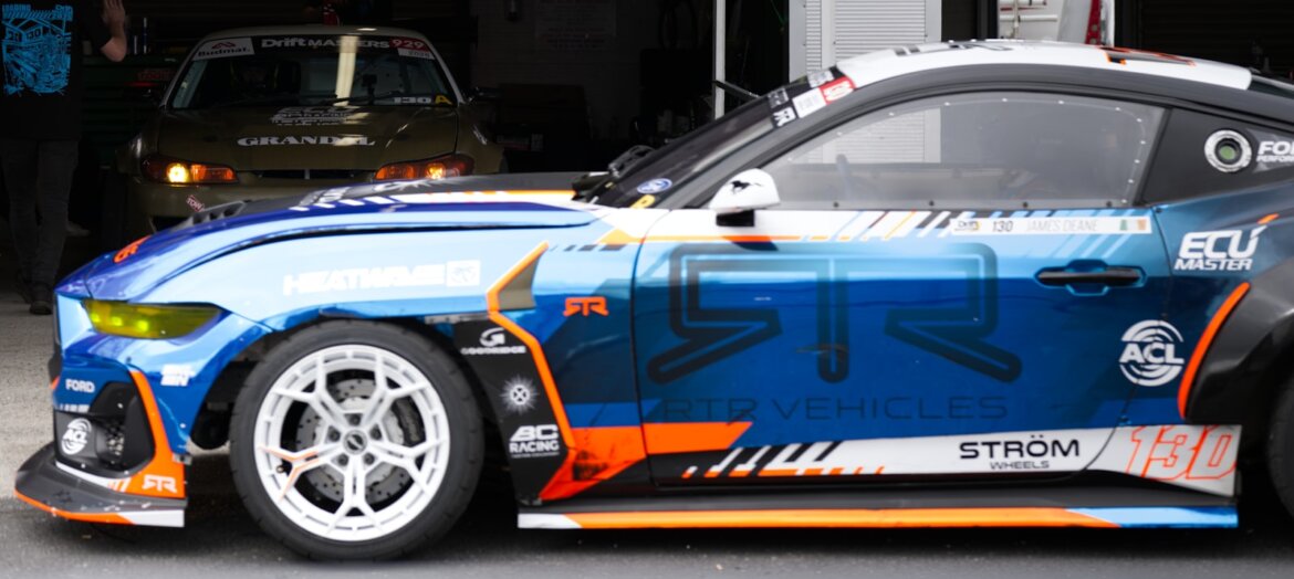 A custom race car is shown in a garage.