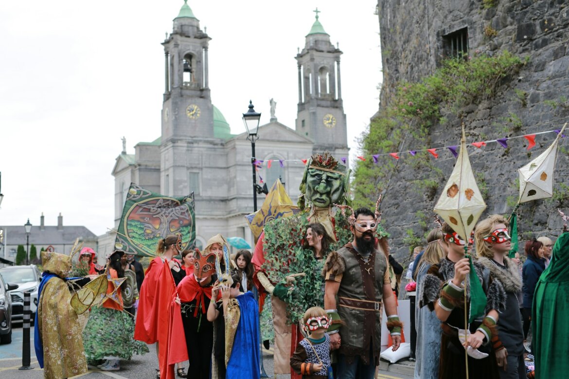 People in costumes marching in a street parade.