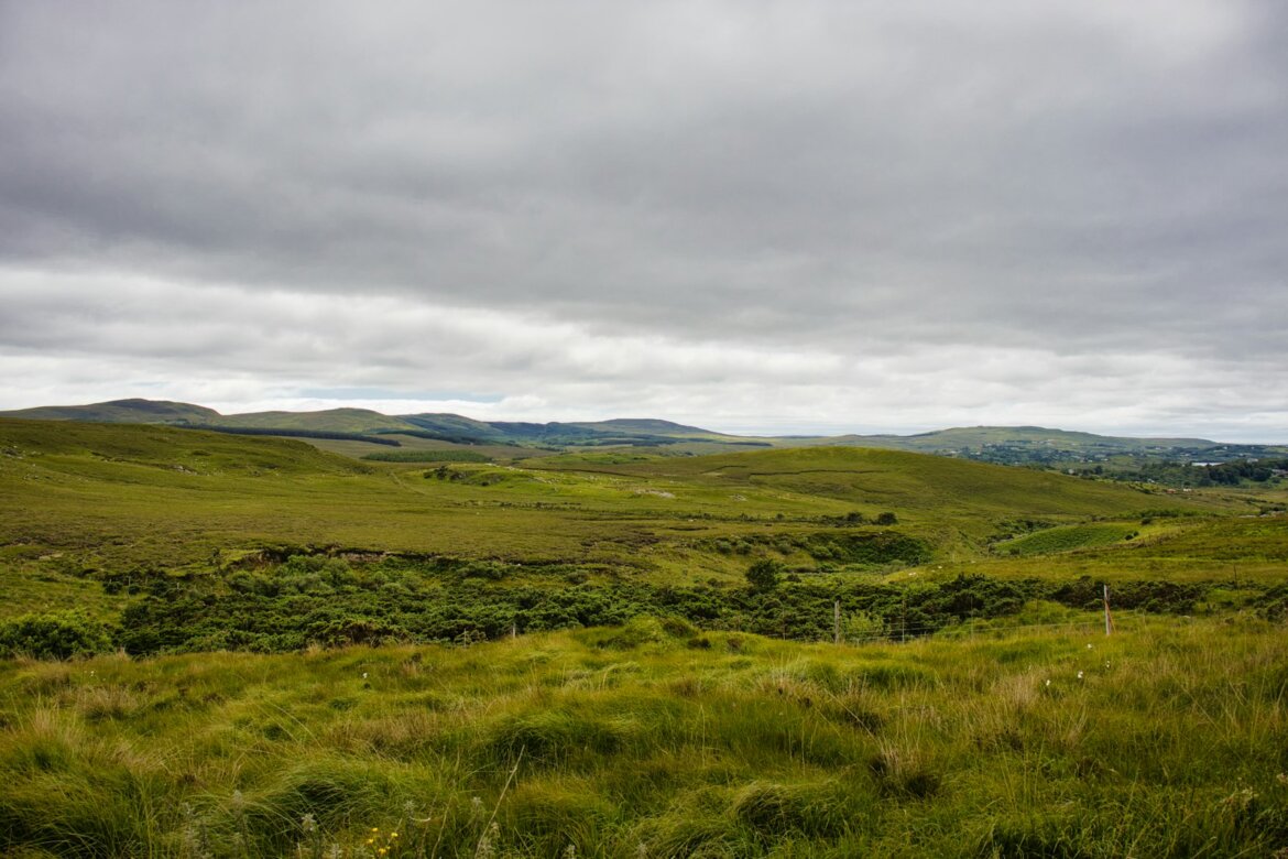 Rolling green hills under a cloudy sky
