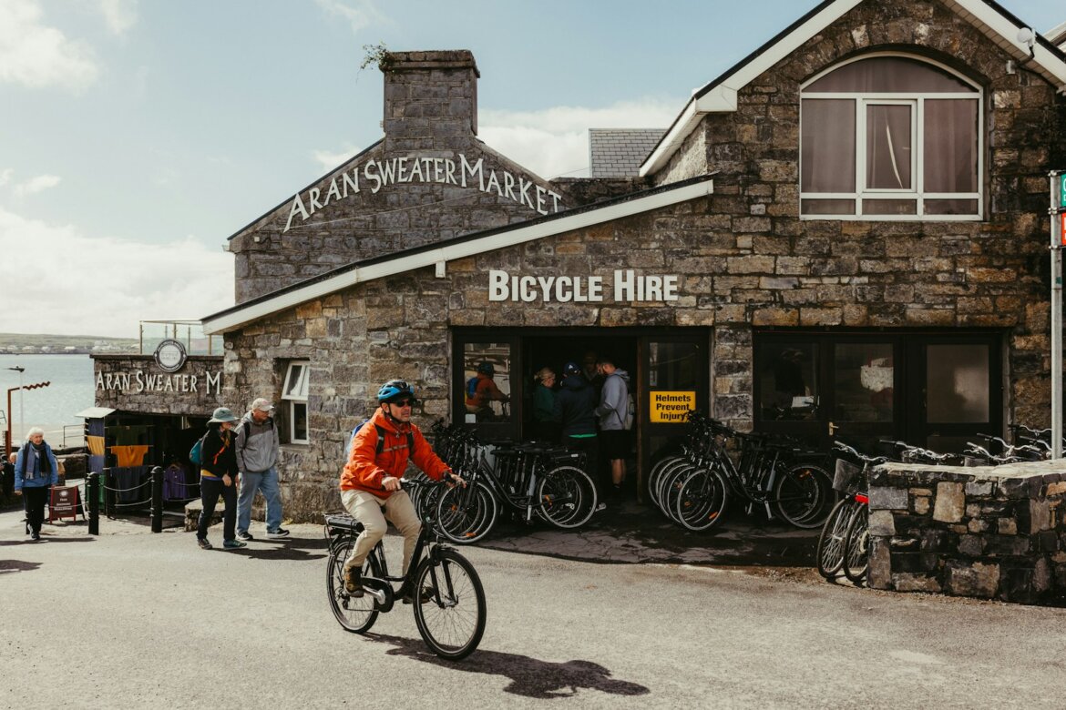 Cyclist rides past a bicycle hire shop
