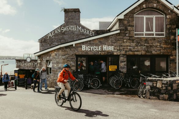 Cyclist rides past a bicycle hire shop