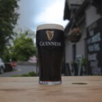 a pint of guinness on a table outside a pub