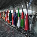 Row of national flags displayed indoors