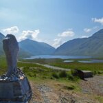 a statue of a person standing on top of a hill
