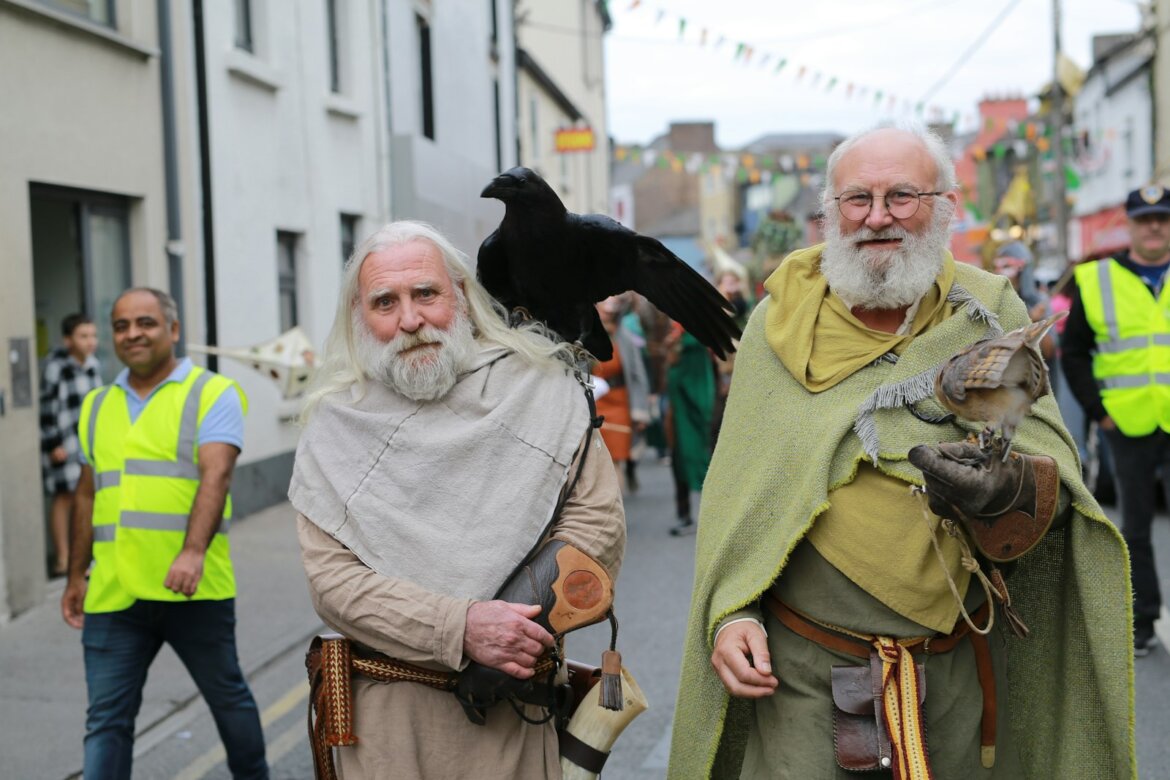 Two men in historical costumes with birds