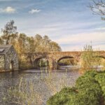 brown concrete bridge over river under white clouds and blue sky during daytime