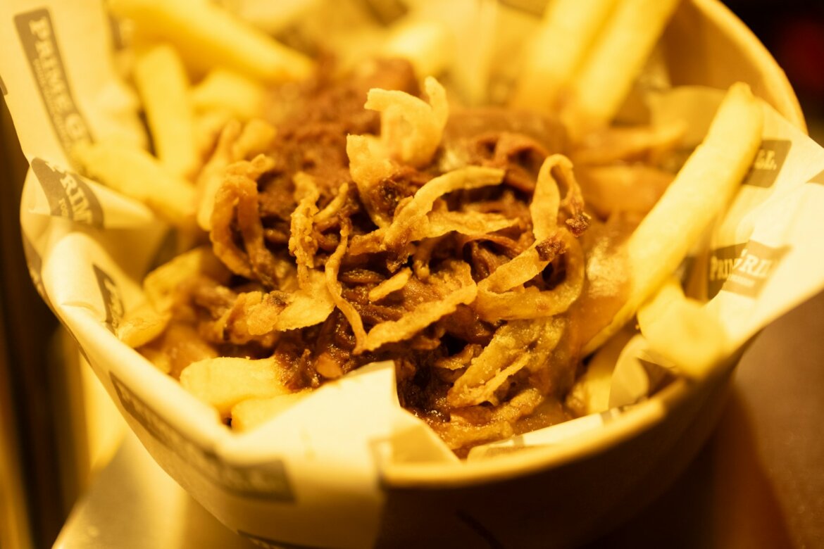 Basket of french fries with fried onions